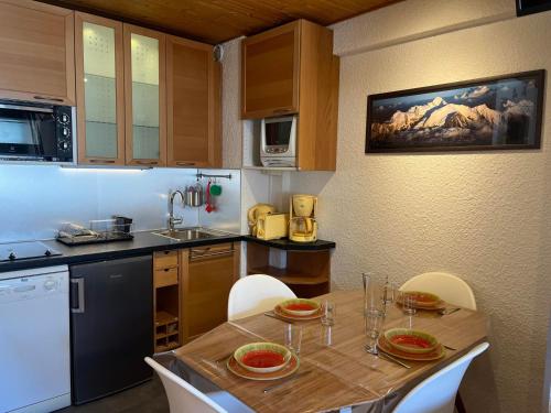 - une cuisine avec une table en bois, des chaises et un évier dans l'établissement Appartement cozy aux Gets - Ski-in/Ski-out, proche centre et commodités - FR-1-623-214, aux Gets