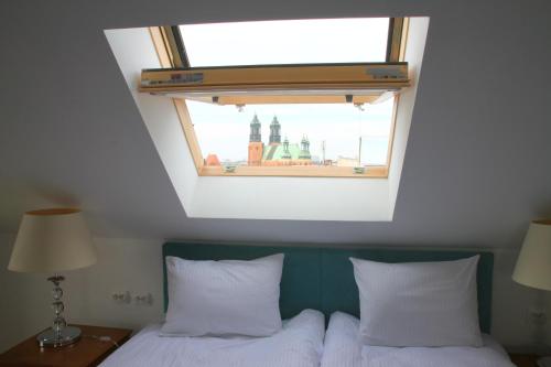 a bedroom with a window above two beds at Śródka Boutique Hotel in Poznań