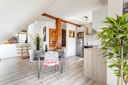 une cuisine et une salle à manger avec une table et des chaises dans l'établissement Les Glycines du Sommerberg, à Niedermorschwihr