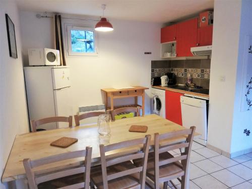 una cocina con mesa de madera y sillas. en Résidence Pyrénées Zenith, en Luz-Saint-Sauveur