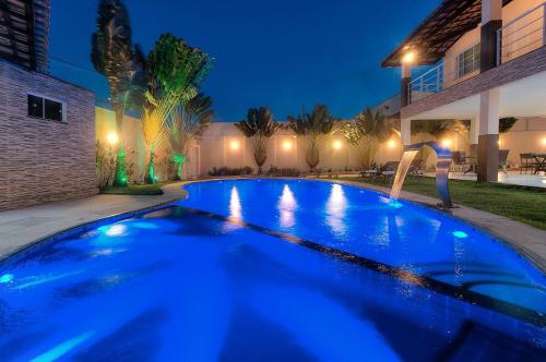 a woman doing a yoga pose in a swimming pool at night at Casa Incrível na Praia de Tabuba by Carpediem in Cumbuco