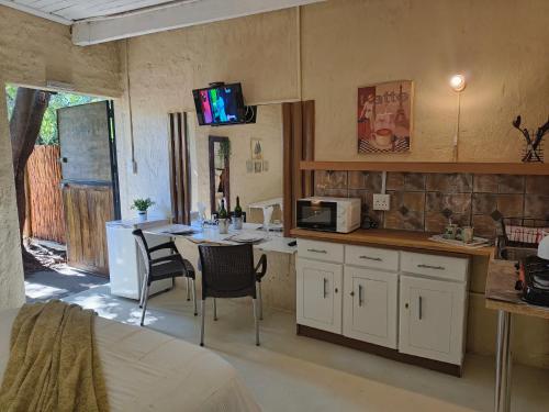 a kitchen with a table with chairs and a microwave at Shangrila-innibos Country Lodge in Hartbeespoort