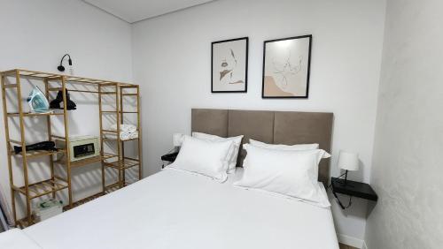 a bedroom with a large white bed with white pillows at 3S Apartments -Sea-Sun-Sky- in Sarandë