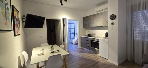 a kitchen with a white table and a table and chairs at 3S Apartments -Sea-Sun-Sky- in Sarandë