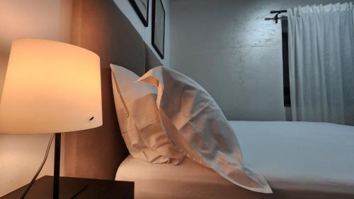 a bedroom with a bed and a lamp and a pillow at 3S Apartments -Sea-Sun-Sky- in Sarandë