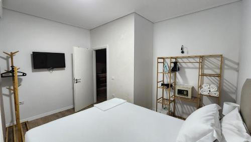 a white room with a bed and a television at 3S Apartments -Sea-Sun-Sky- in Sarandë