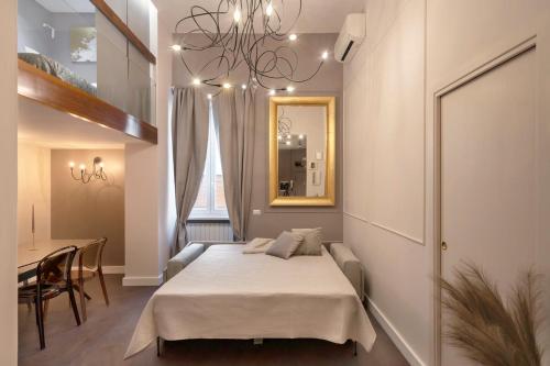 ローマにあるTrevi Luxury Terraceのベッドルーム(ベッド1台、テーブル、鏡付)
