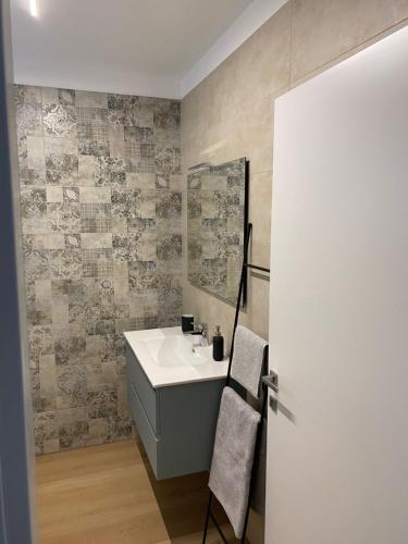 uma casa de banho com um lavatório e um espelho em Lotus Garda em Riva del Garda