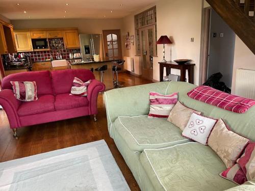 salon z 2 kanapami i czerwoną kanapą w obiekcie Beautiful Stratford-On-Avon House, suits 14 - 15 w mieście Shottery