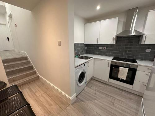 a kitchen with a washing machine and a staircase at London Westminster nearby Zone1 in London