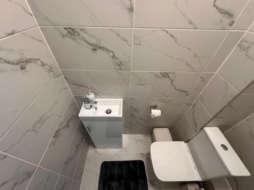 a white bathroom with a toilet and a sink at London Westminster nearby Zone1 in London