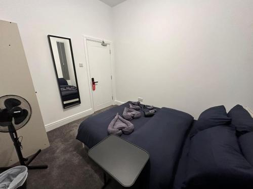 a bedroom with a blue bed and a mirror at Vauxhall Victoria moments away in London