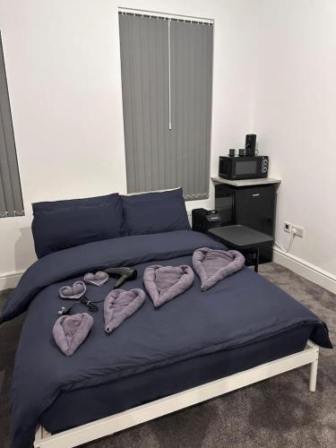 a bed with purple sheets and pink towels and scissors at Vauxhall Victoria moments away in London