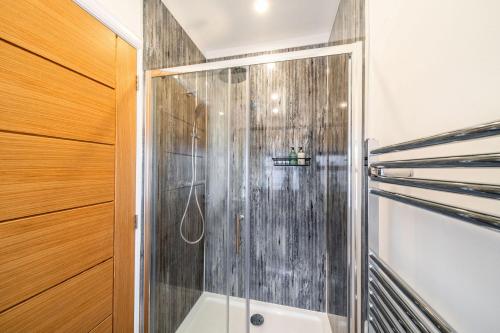 W łazience znajduje się prysznic ze szklanymi drzwiami. w obiekcie The Corner House w mieście Hopeman
