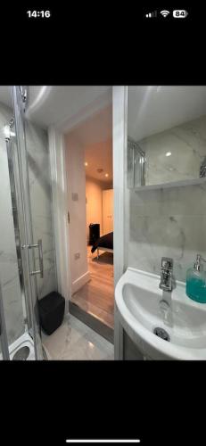 a white bathroom with a shower and a sink at London Eye 15 minutes away in London