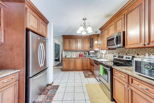 a kitchen with wooden cabinets and a stainless steel refrigerator at Tobyhanna Home with Fire Pit 1 Mi to Lake Carobeth! in Tobyhanna