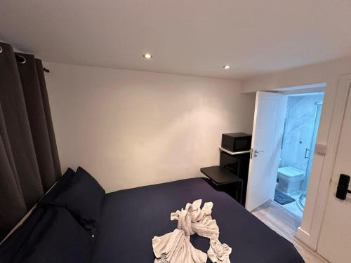 a bedroom with a black bed and a bathroom at Central London Zone1 Room - Bath in London