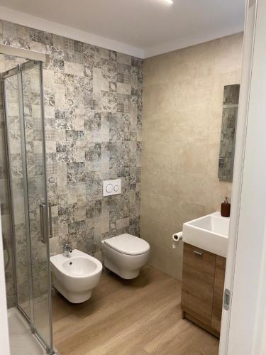 a bathroom with a toilet and a sink at Lotus Garda in Riva del Garda