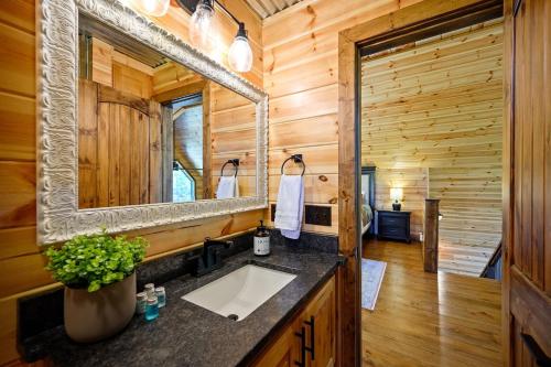 a bathroom with a sink and a mirror at Stunning Balcony View Frequent Deer Sightings in Broken Bow