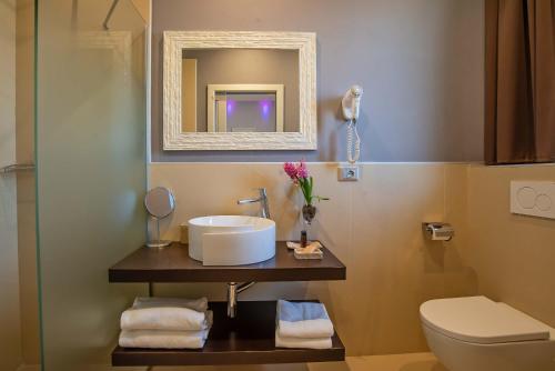 uma casa de banho com um lavatório, um WC e um espelho. em Hotel Orcagna em Florença
