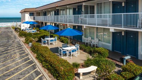 uma varanda de um hotel com mesas e guarda-sóis em Fantasy Island Resort I em Daytona Beach Shores