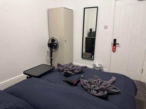 a bedroom with a bed with purple sheets and a mirror at Buckingham Palace - Hyde Park near in London