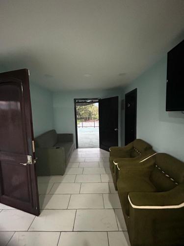 a living room with couches and a room with a door at Casa Tabacon cr in Río Claro