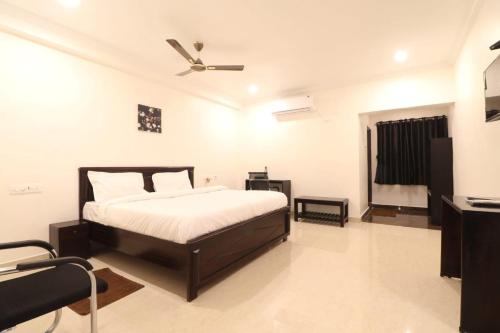een slaapkamer met een bed en een plafondventilator bij MN Stays in Vijayawāda