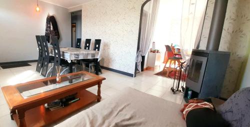 uma sala de estar com uma mesa e uma lareira em Charmante maison néo-bretonne em Plumaudan