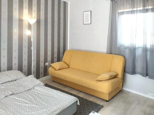 un sofá amarillo en un dormitorio junto a una cama en One bedroom apartement with balcony and wifi at Vir, en Vir