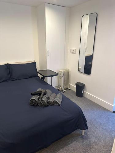 a bedroom with a bed with headphones and a mirror at Buckingham Palace 15minutes away in London