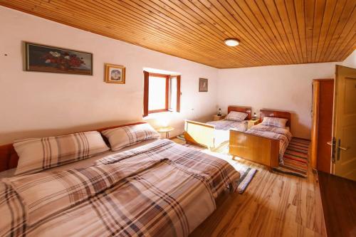 SinacにあるKuca za odmor Lipaのベッドが2つあり、天井が木製の寝室