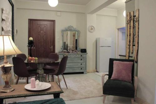 een woonkamer met een tafel en stoelen en een koelkast bij Lucato apartment in Florina