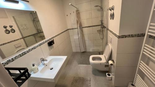 uma casa de banho branca com um lavatório e um WC em Reviv - Traumhaftes 3 Zimmer Apartment em Brühl