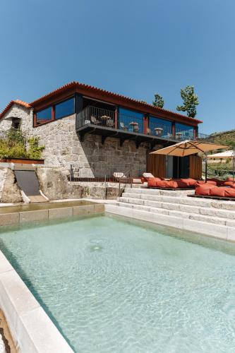 a swimming pool in front of a house at D'Autor Village in Valadares