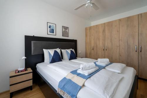 ein Schlafzimmer mit einem großen Bett mit blauen und weißen Kissen in der Unterkunft HM • Urban 1BR Retreat, Easy City Link in Wien