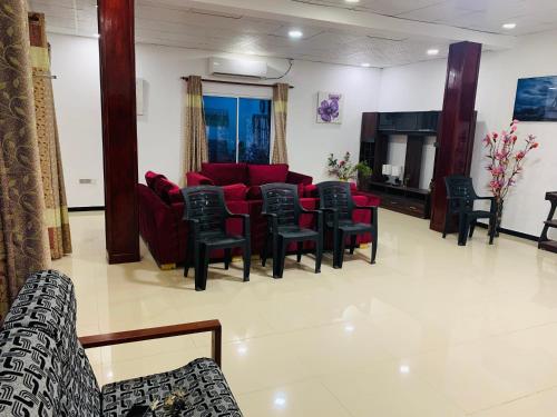 una sala de espera con sofás y sillas rojos en Meenatchi illam, en Trincomalee