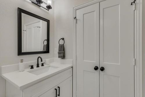 a white bathroom with a sink and a mirror at Gorgeous Sunny Home for Big Groups w Private Pool in Garland