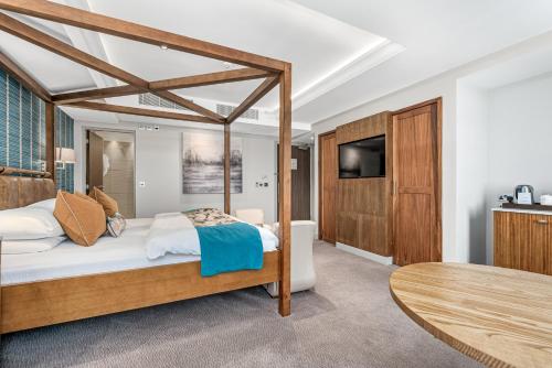 a bedroom with a bed and a tv and a table at Spa Hotel at Ribby Hall Village in Wrea Green