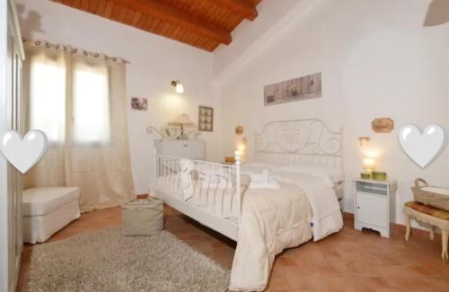 a bedroom with a white bed with hearts on the wall at Il Rifugio della Quiete in Scicli