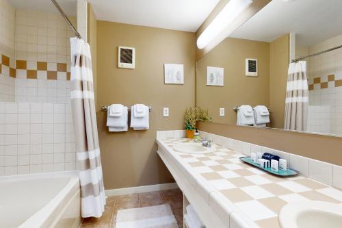 a bathroom with two sinks and a tub and a mirror at Cascade Bay Getaway in Eastsound