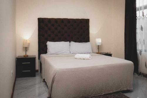 a bedroom with a large bed with a large headboard at Kumwitu Luxury Apartments in Lusaka
