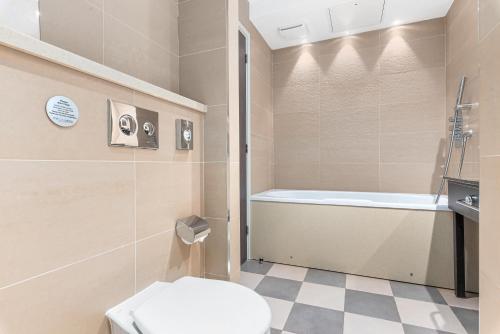 a bathroom with a toilet and a bath tub at Spa Hotel at Ribby Hall Village in Wrea Green