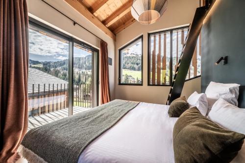 une chambre avec un lit et une grande fenêtre dans l'établissement Chalet Nelcote Morzine - by EMERALD STAY, à Morzine