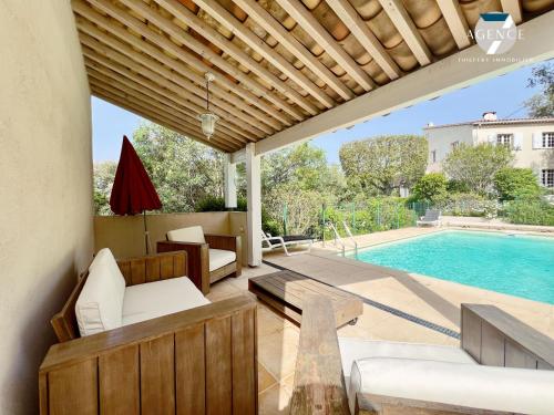 un patio avec une table et une piscine dans l'établissement La Louarde, aux Issambres