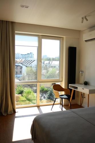 - une chambre avec un lit, un bureau et une fenêtre dans l'établissement Your Home in Chisinau: Private Parking and Peaceful Stay, à Chişinău