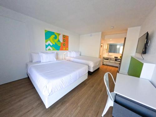 Cette chambre comprend 2 lits et une télévision à écran plat. dans l'établissement Impeccably cozy hotel room Developer Inn Express, à Kissimmee