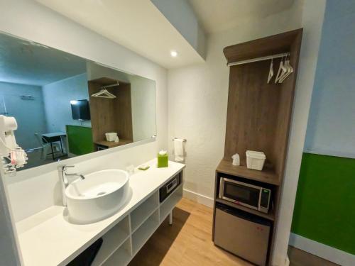 W łazience znajduje się umywalka i kuchenka mikrofalowa. w obiekcie Impeccably cozy hotel room Developer Inn Express w mieście Kissimmee