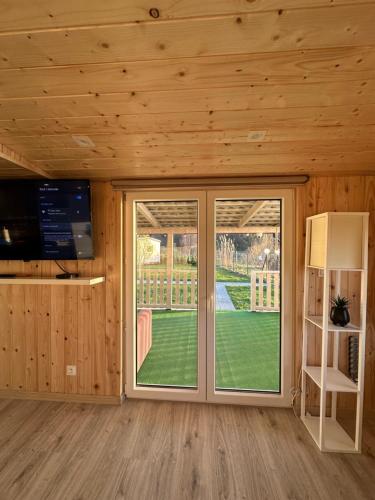 a room with a sliding glass door with a view of a yard at Domki Nad Sanem Bachórzec 6a in Dubiecko