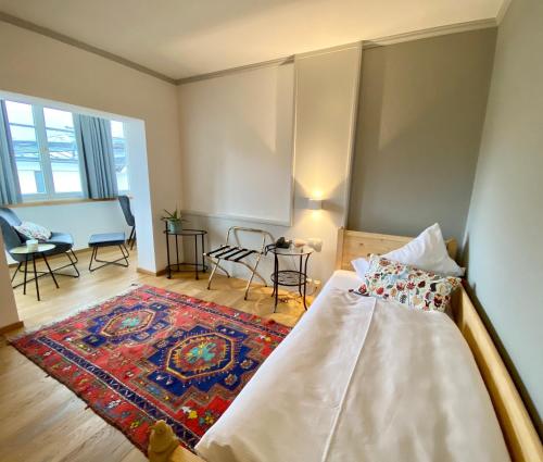 a bedroom with a bed and a living room at Boutiquehotel Hubertushof in Bad Ischl